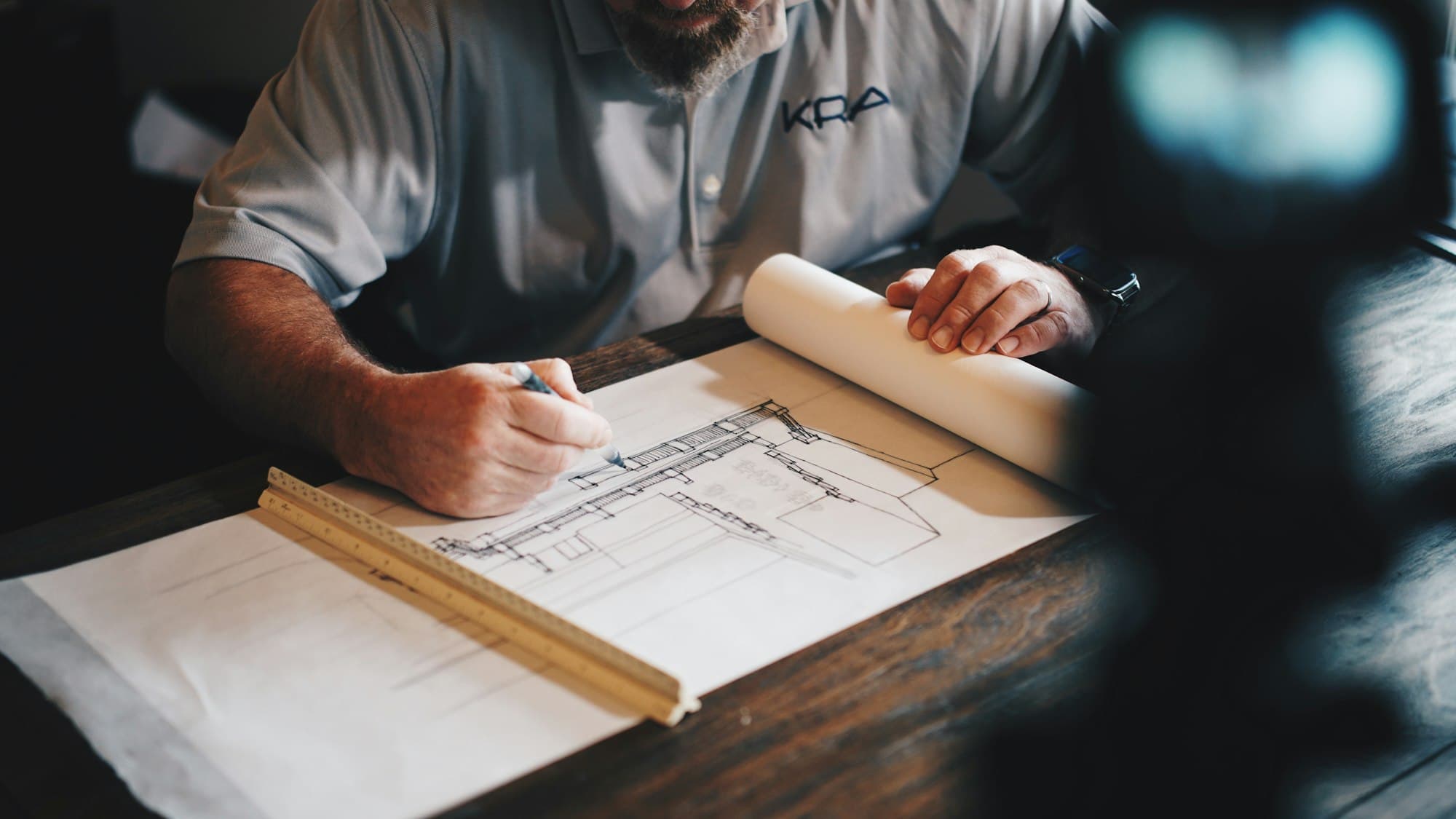 Hands drafting a plan at a table